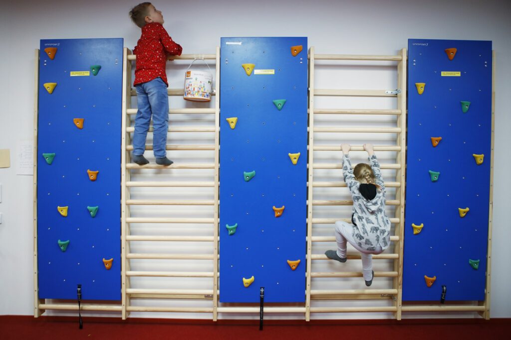 Two children are climbing on a climbing frame