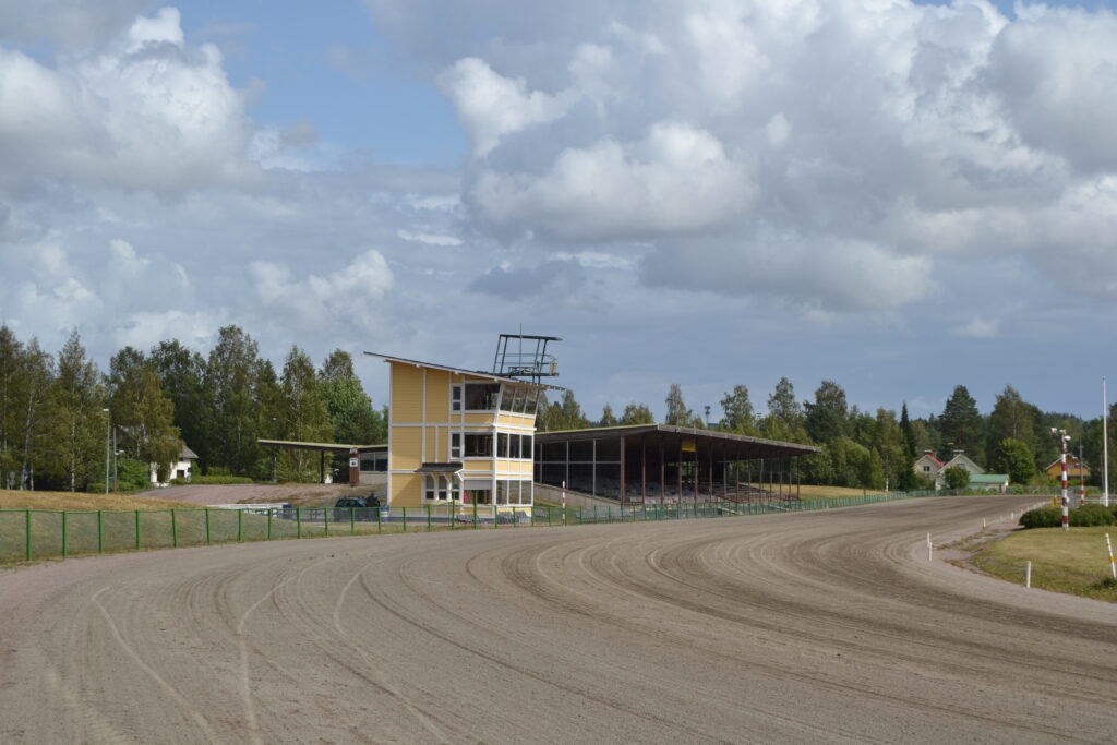 The track's hoof groove, referee and press tower, and grandstand building.