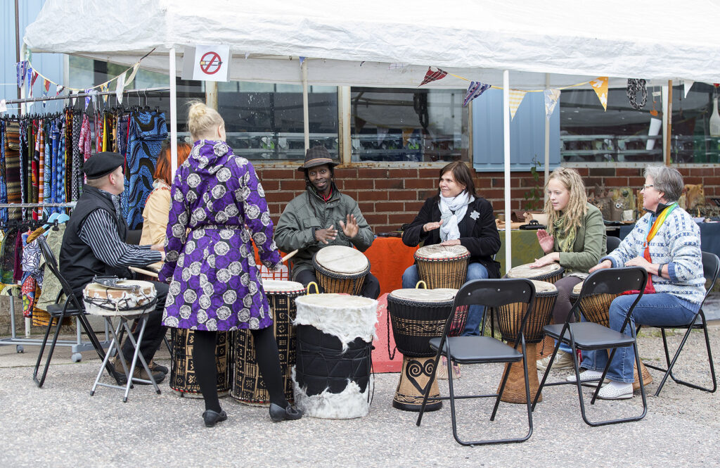 A group of people play drums in a ring at the Illusio event.