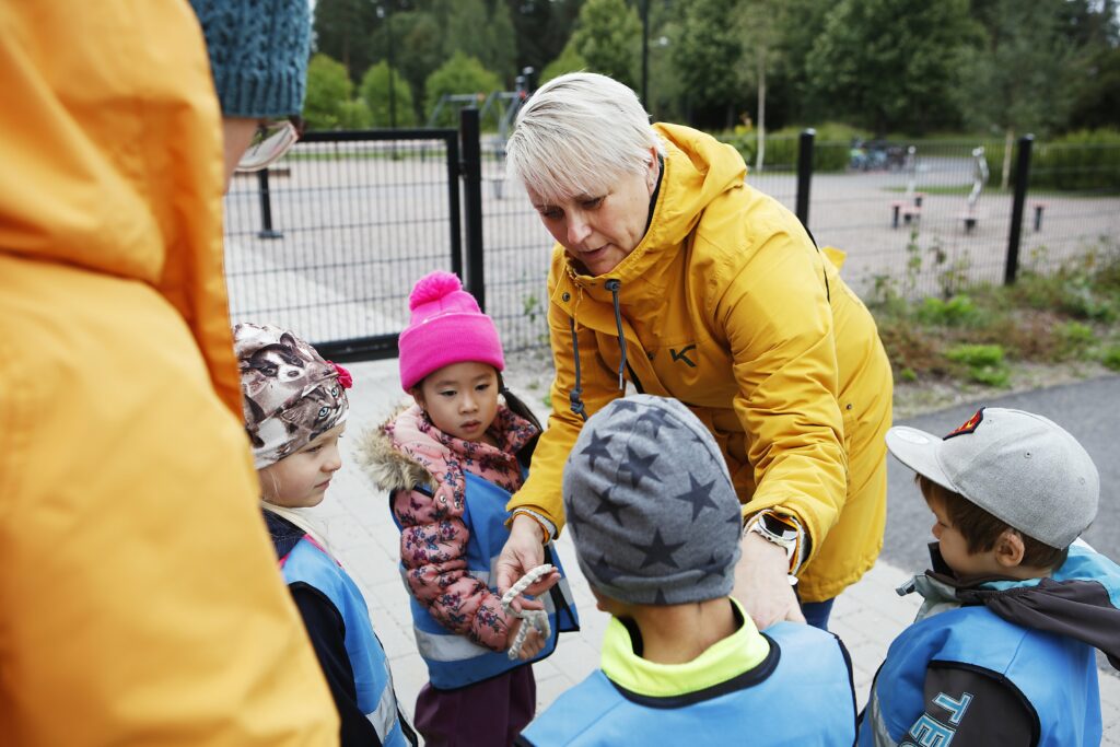 päiväkodin työntekijät lasten kanssa pihalla