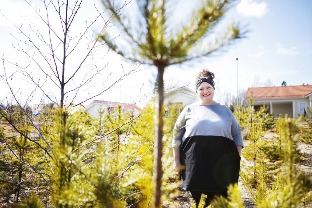 Niina Matkala seisoo Metsäkorven asuntoalueella olevalla ruohikolla