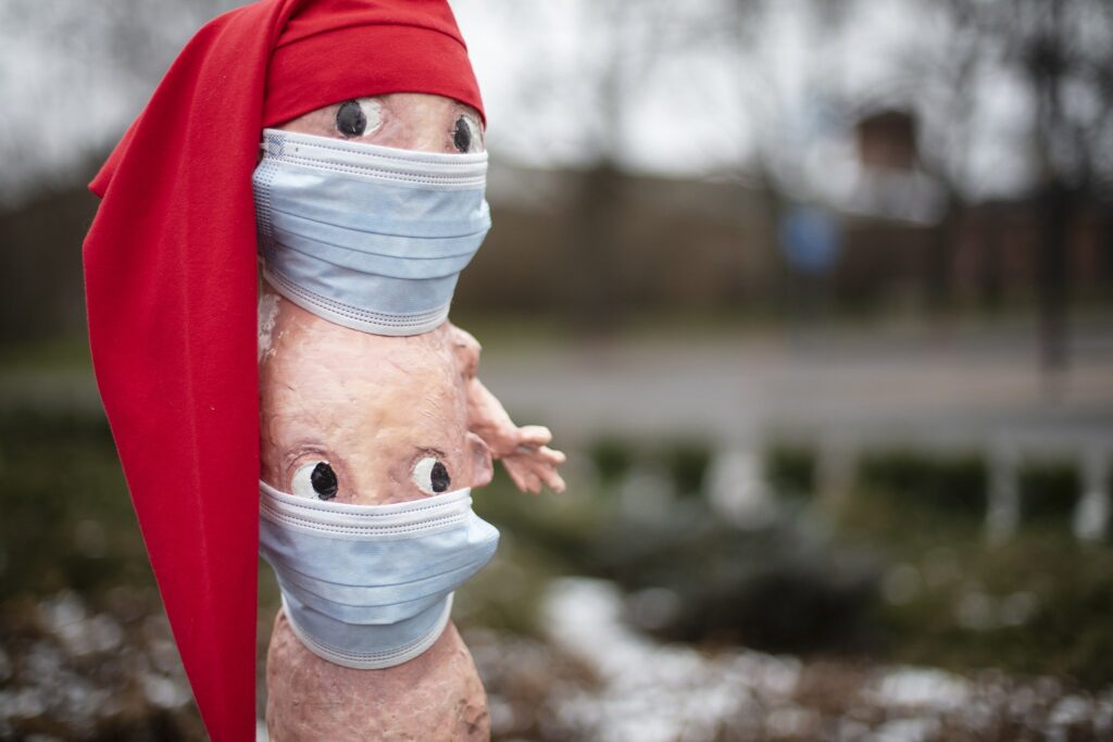 Eksynyt-patsas tonttulakki päässä ja maski kasvoillaan