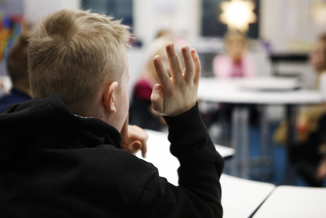 Lapsi viittaa luokassa.