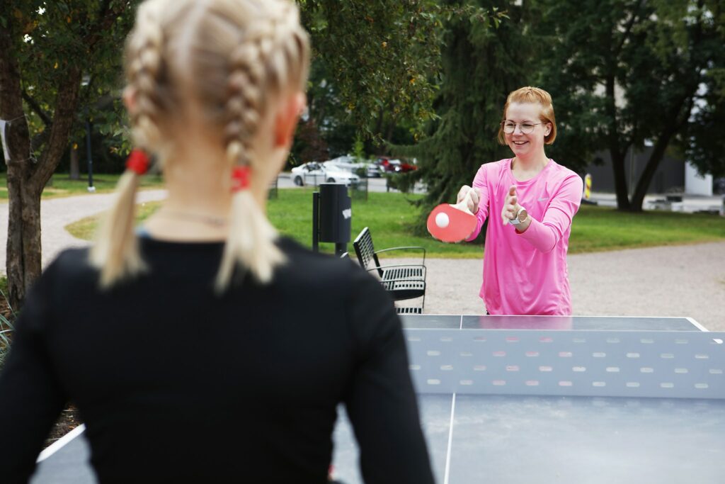 Unga människor spelar pingis i parken