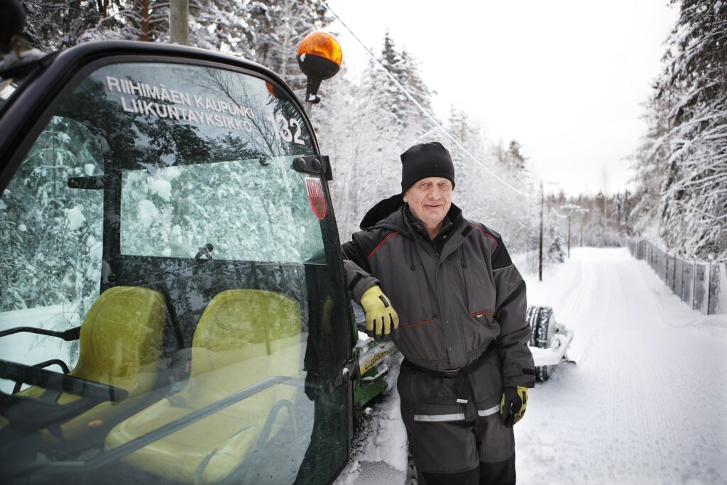 Mies nojaa latukoneeseen lumisessa metsässä