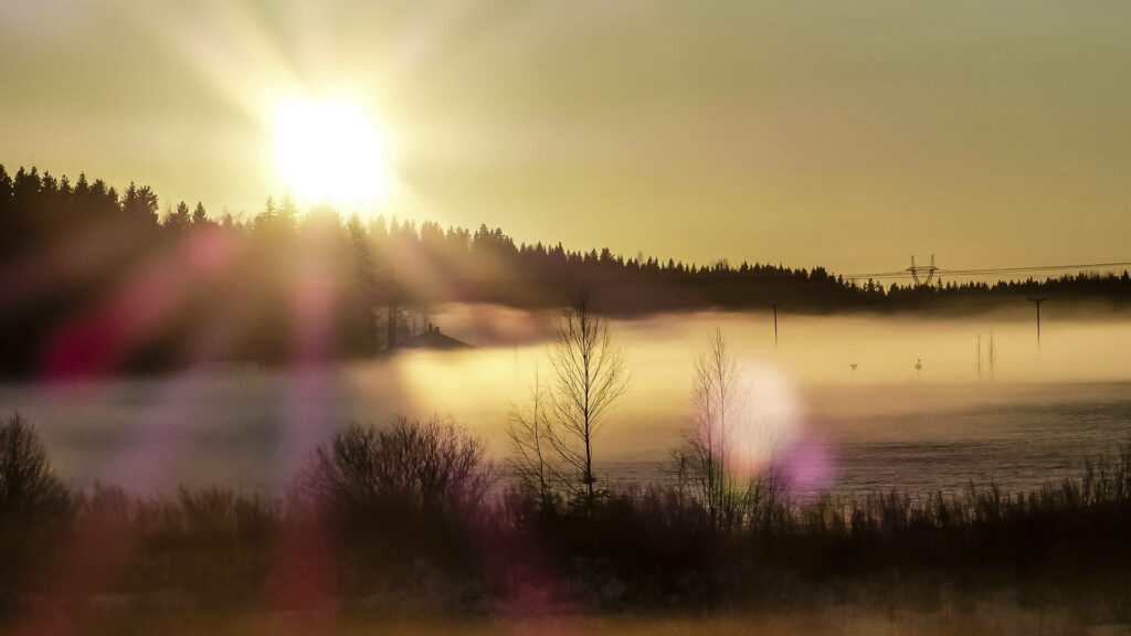 Aurinko laskee usvaisella suolla.