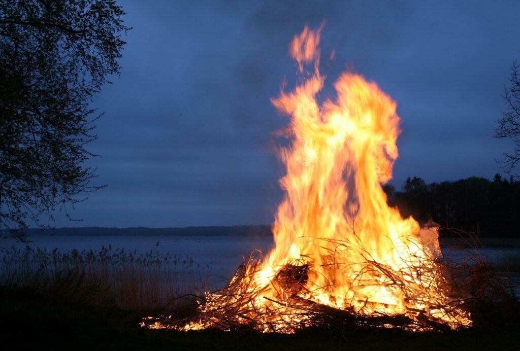 Juhannuskokko järvenrannalla iltahämärässä.