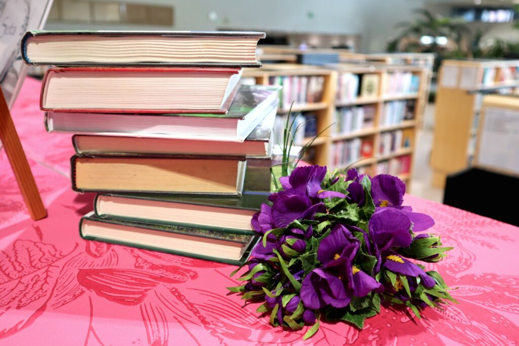 Kirjoja, kirjahyllyjä ja kukkia aikuistenosastolla