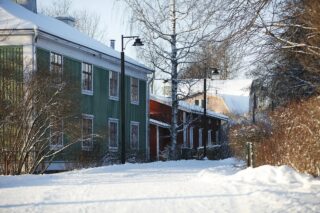 Rautatienpuisto Maantie på vintern, bilden visar gamla färgglada trähus.