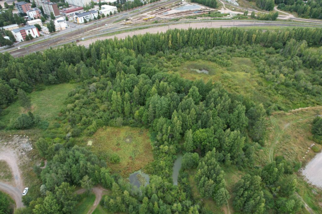 Peltosaari Wetland Park seen from above, the wetland park is right next to the train track.