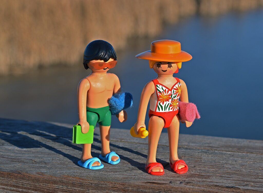 Nainen ja mies legofiguurit puisen laudan päällä ranta-asuissa.