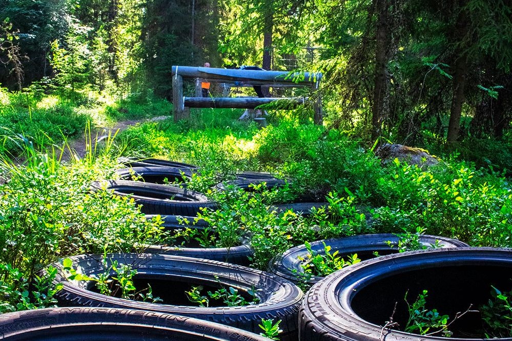 metsäkuntosalista kuva, jossa ratamaisesti autonrenkaita