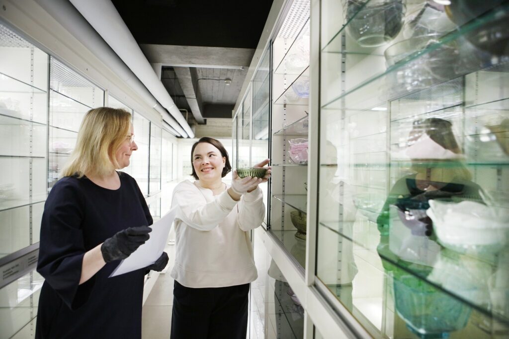 Glass museum employees present a glass object.