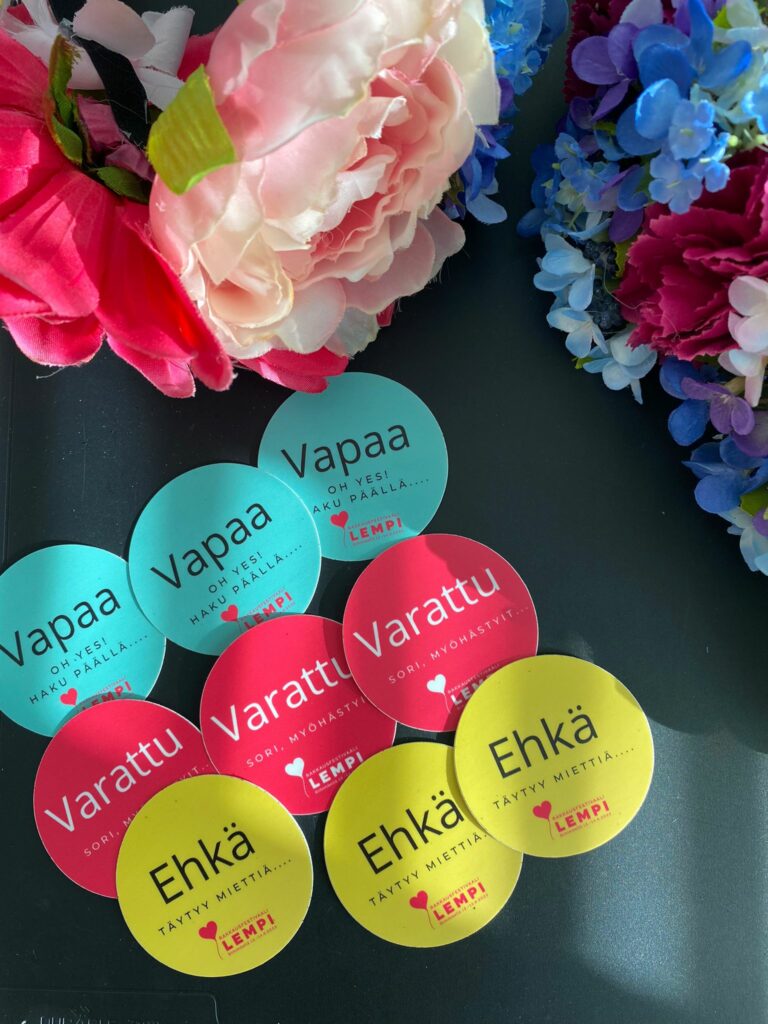 Round stickers on the table and colorful flowers above them.