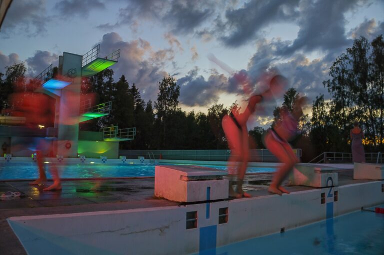 People jumping into the pool at the land swimming pool.