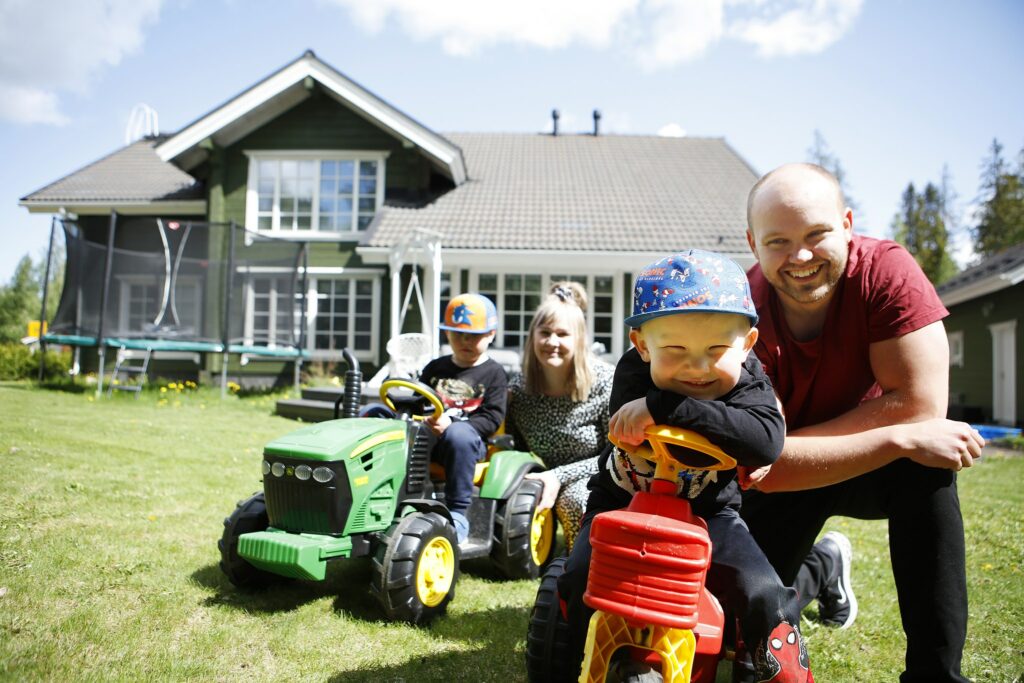 Familjen Hakomäki, mamma, pappa och två barn, på gården till sitt småhus.