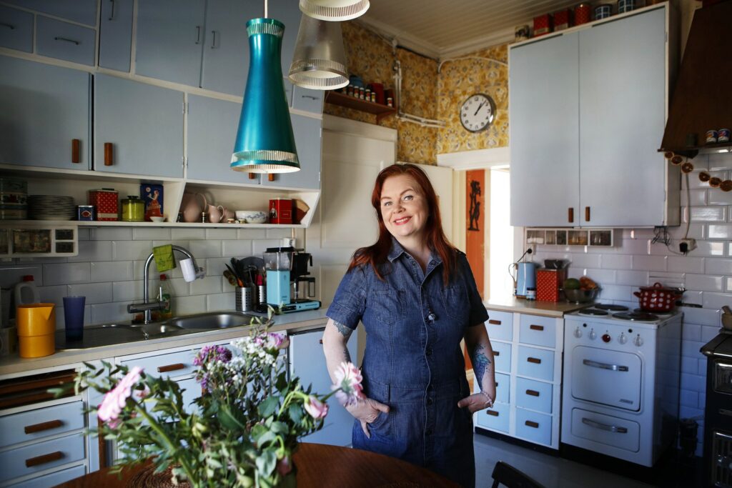 Outi Hallikainen stands in his 50s-inspired kitchen.