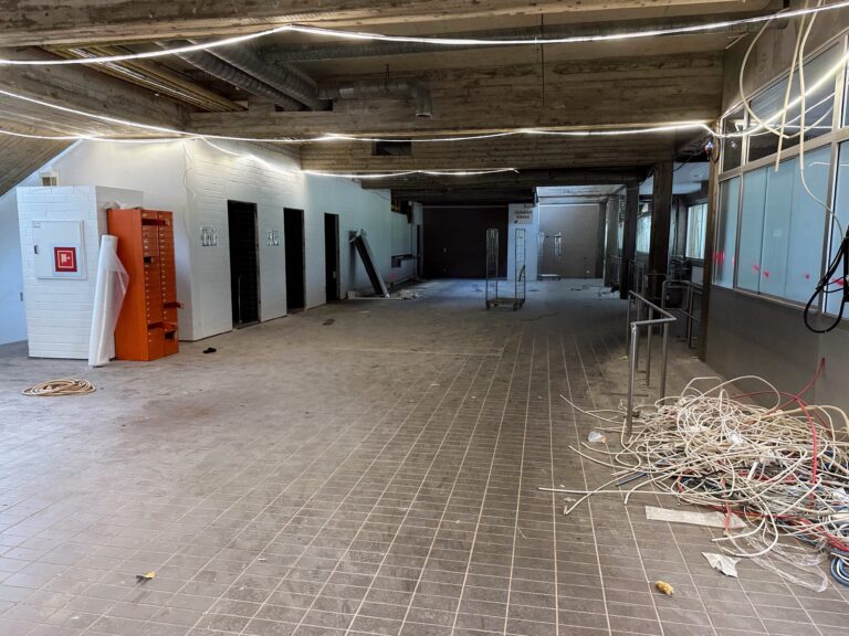 The picture shows Riihimäki's swimming hall from the inside of the main lobby, with demolition waste on the floor.