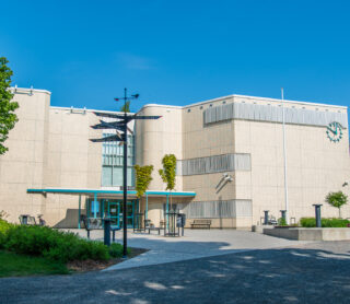 The facade of the library, in front of which is the library park and seating.