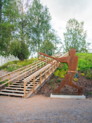 Trätrappa för träning och en spik som håller Piikinmäki-skylten.