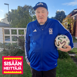 A person dressed in a blue tracksuit with a soccer ball under his arm in a green summer yard. At the bottom of the picture, the text logo Väisänheittäjä