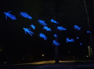 Blue human figures fly in the same direction in the dark night sky.