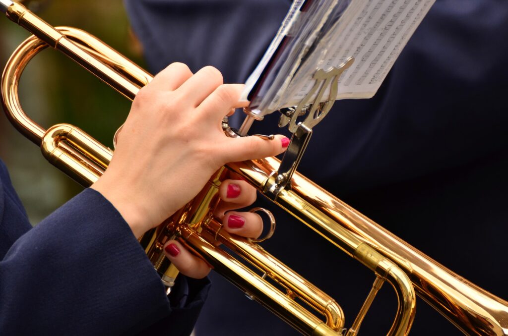 En glänsande trumpet och spelarens fingrar.