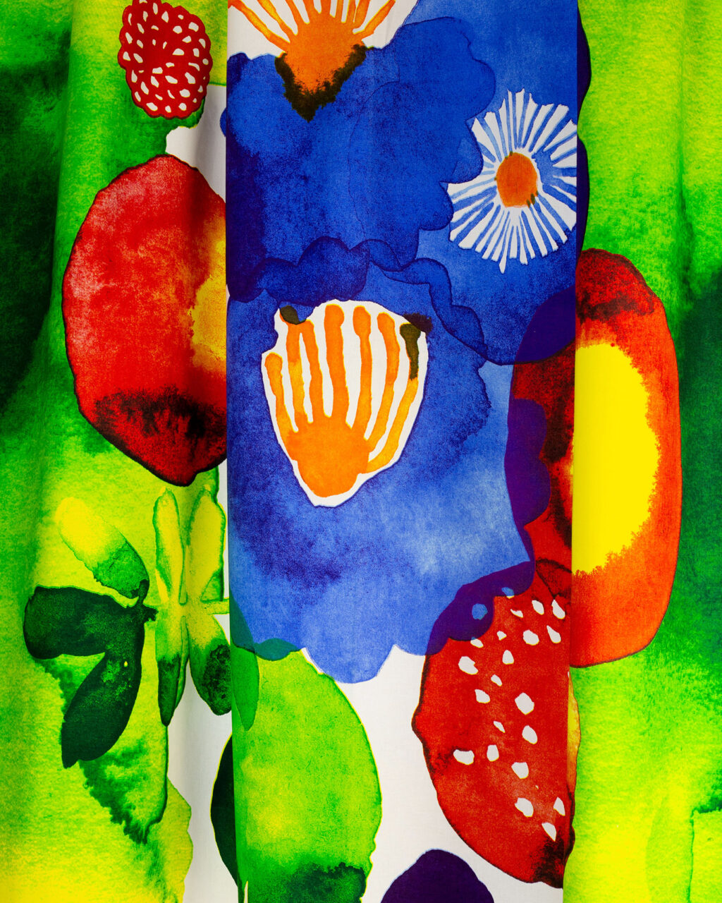 A colorful fabric designed by Aino-Maija Metsola, with, among other things, colorful flowers.
