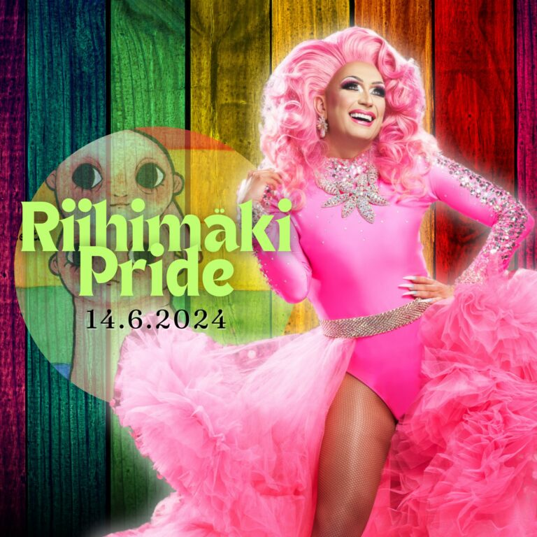 Drag-tähti Divet seisoo upeassa vaaleanpunaisessa tyllihameessa ja hymyilee.