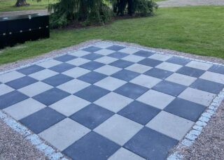 Etualalla betonilaatoista tehty ulkoshakkilauta, taka-alalla näkyy Riihimäen kirjasto