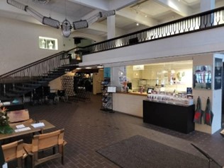Aula, jossa tuoli penkkeineen, rappuset yläkertaan ja lipunmyyntikoppi.