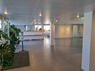 Avara aulatila, jonka perällä lipunmyyntipiste ja info.