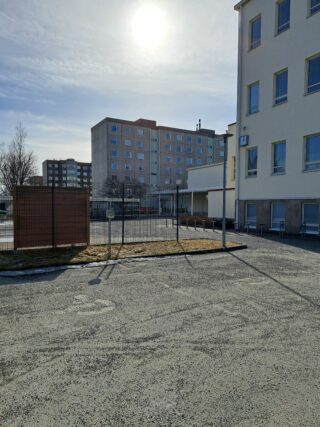 Rakennusten välissä oleva sisäpiha, jossa pysäköintipaikka invatunnuksella.