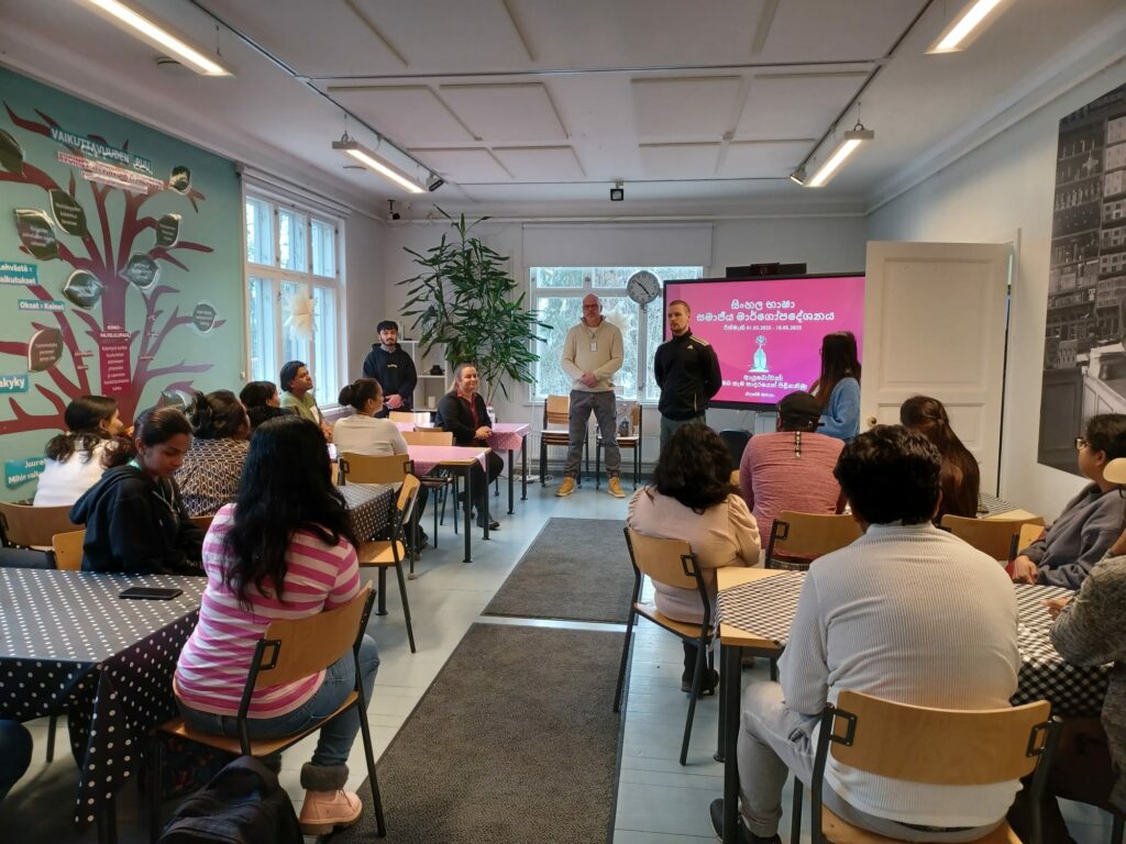 Ryhmä henkilöitä kuuntelemassa puhujaa