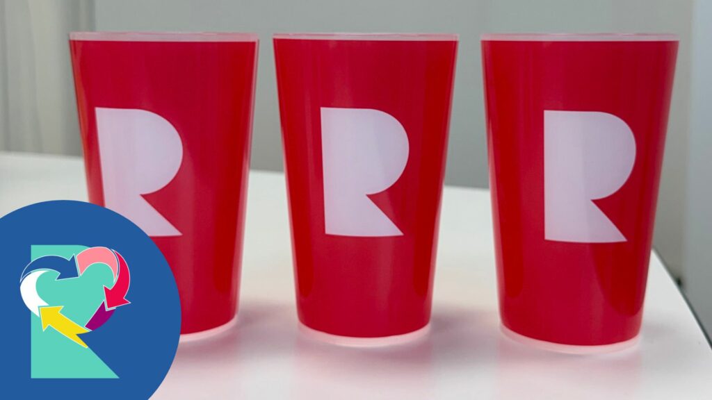 kolme punaista uudelleenkäytettävää kuppia, joissa Riihimäen kaupungin R-tunnus.