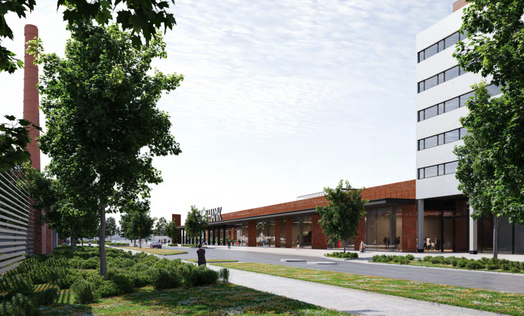 Havainnekuva: Näkymä Eteläiseltä Asemakadulta pohjoiseen kohti uutta HAMKin kampusta. Laajennus on pääosin yksikerroksinen, julkisivu on ruosteen väristä metallia ja ikkunapintaa. On lähes pilvetön kesäpäivä. Ihmisiä kuljeskelee katuympäristössä.