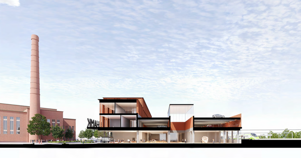 Havainneleikkaus länsi-itäsuunnassa Voimalalta HAMKin uuden kampuksen läpi junaradalle. On lähes pilvetön kesäpäivä. Muutamia opiskelijoita oleilee koulun käytävillä ja luokkahuoneissa.