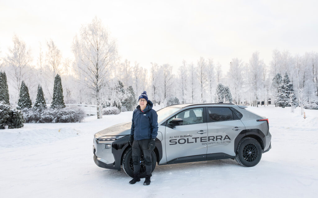 Mies seisoo auton edessä talvella.