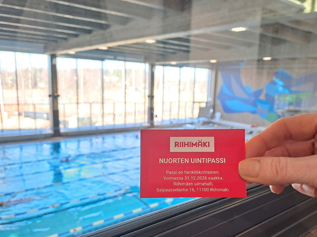 Uimahallin uintirataa vasten punainen lipuke ihmisen kädessä.,